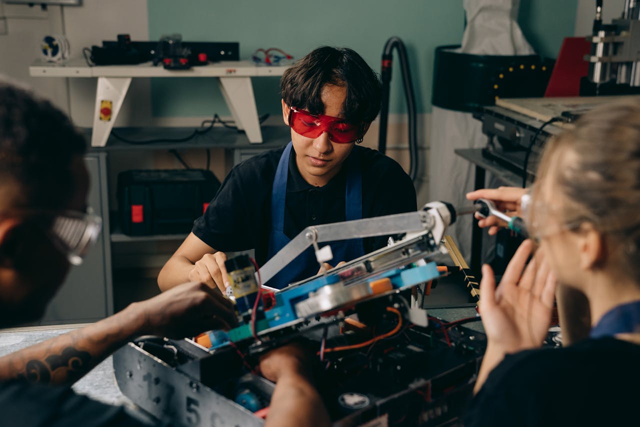 Group of adults working on robotics project in a modern workshop setting.